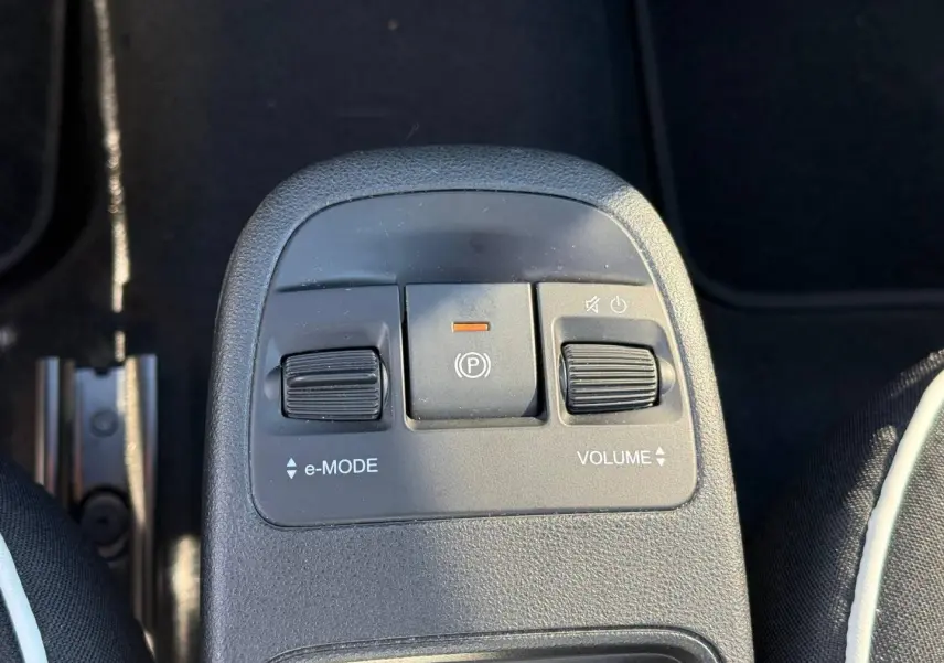 Gros plan sur la console centrale de la Fiat 500 électrique jaune MY24, montrant les commandes e-MODE et volume.