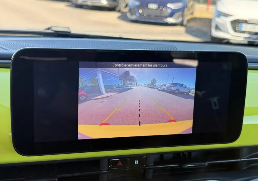 Écran tactile intérieur montrant la caméra de recul d'une Fiat 500 électrique jaune vue de face.
