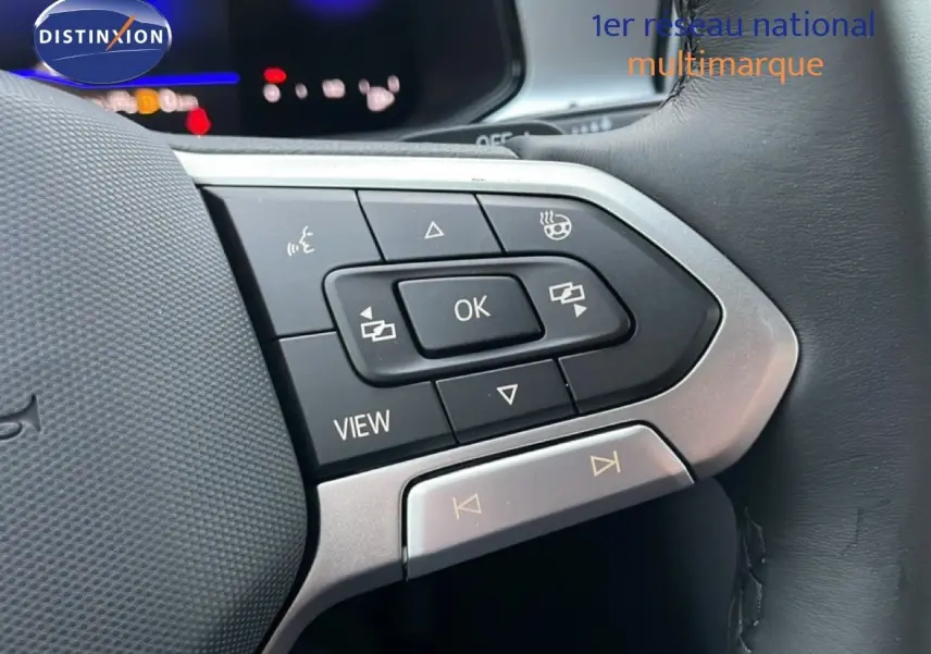 Gros plan sur les commandes multifonctions à droite du volant du Volkswagen T-Roc noir Grenadilla, avec boutons de navigation et vue.