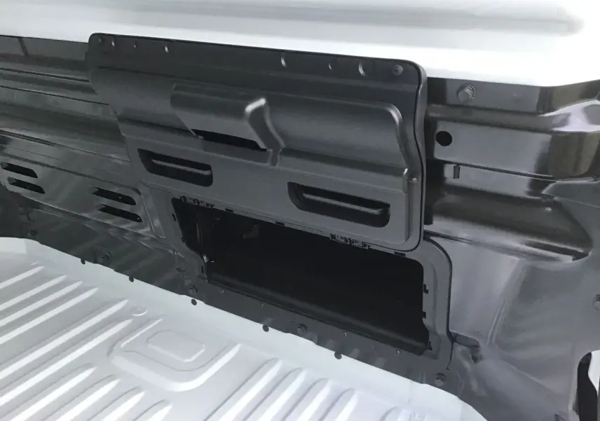 Détail de la cloison avec trappe de charge longue ouverte sur le Renault Trafic Fourgon blanc, vue intérieure.