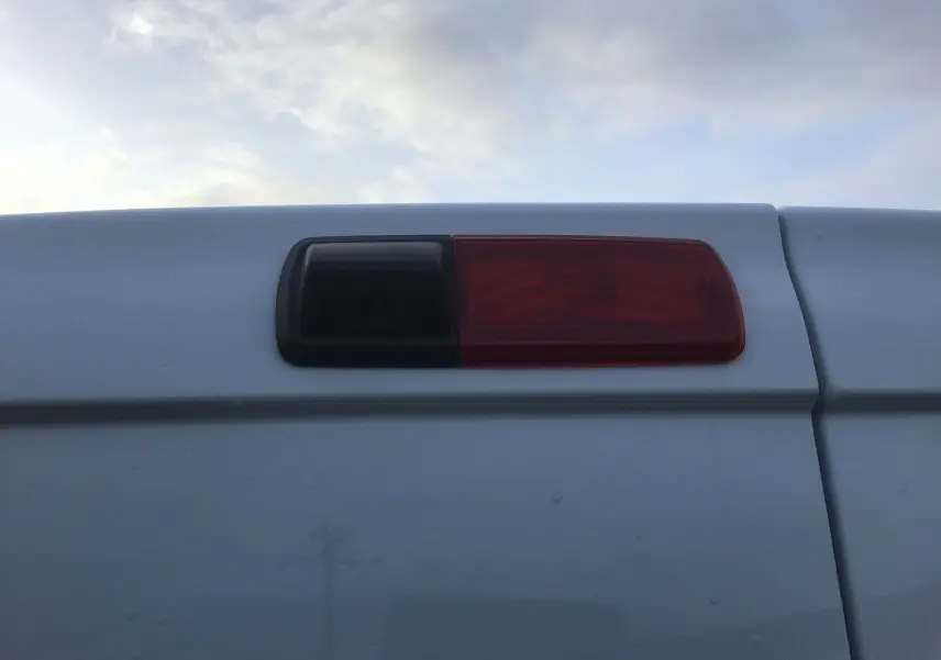 Gros plan sur le feu arrière droit et la caméra de recul du Renault Trafic Fourgon blanc 2025.