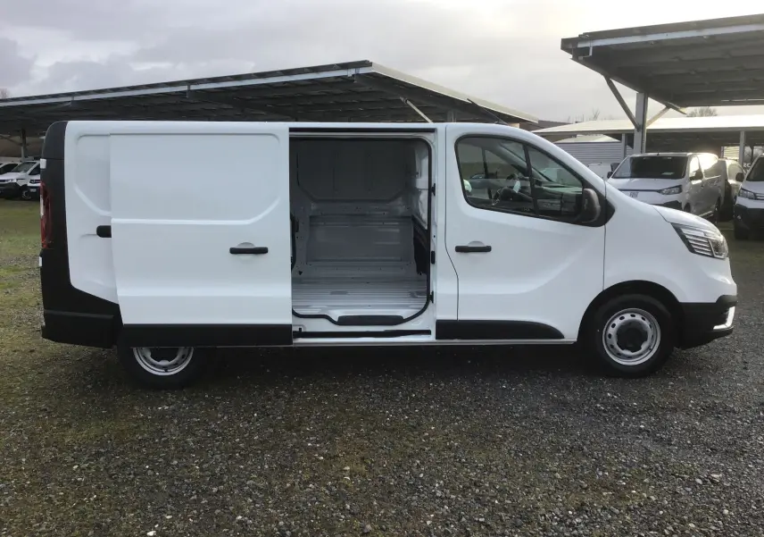 Vue de profil côté droit du Renault Trafic Fourgon blanc 2025 avec porte latérale coulissante ouverte montrant l'espace de chargement vide.