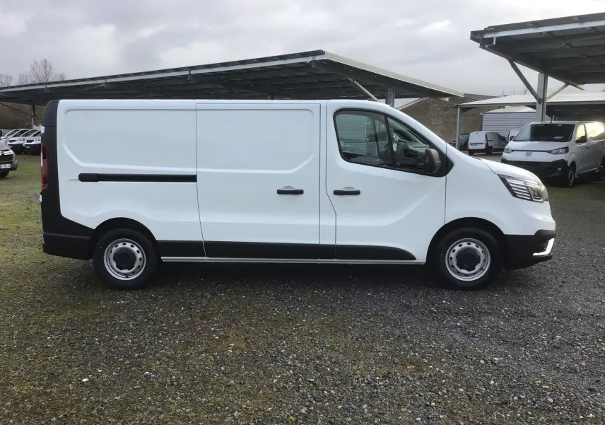 Vue de profil côté gauche d’un Renault Trafic Fourgon blanc 2025 avec porte coulissante et jantes acier noires.