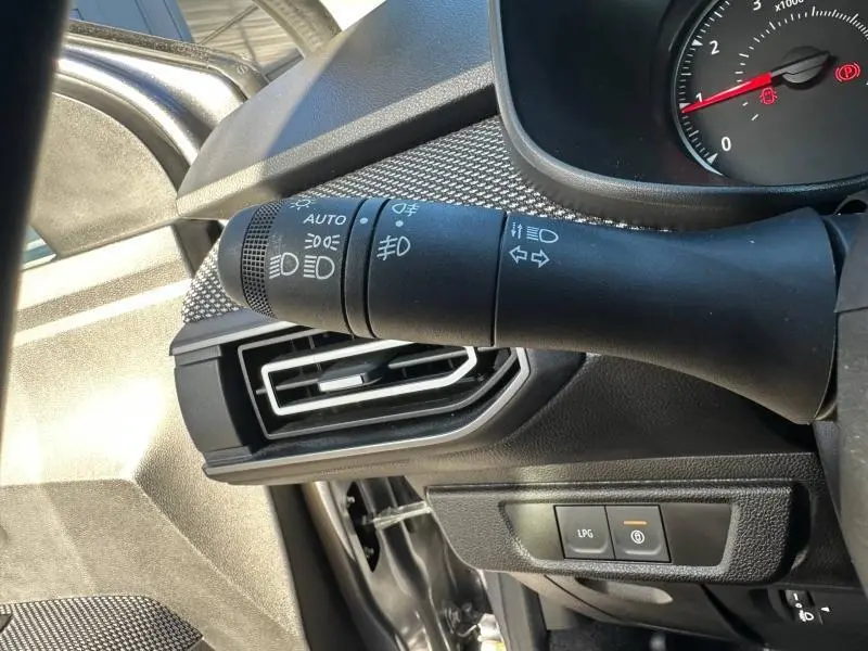 Détail intérieur du commodo d'éclairage et ventilation côté gauche du tableau de bord du Dacia Jogger gris Schiste 2025.