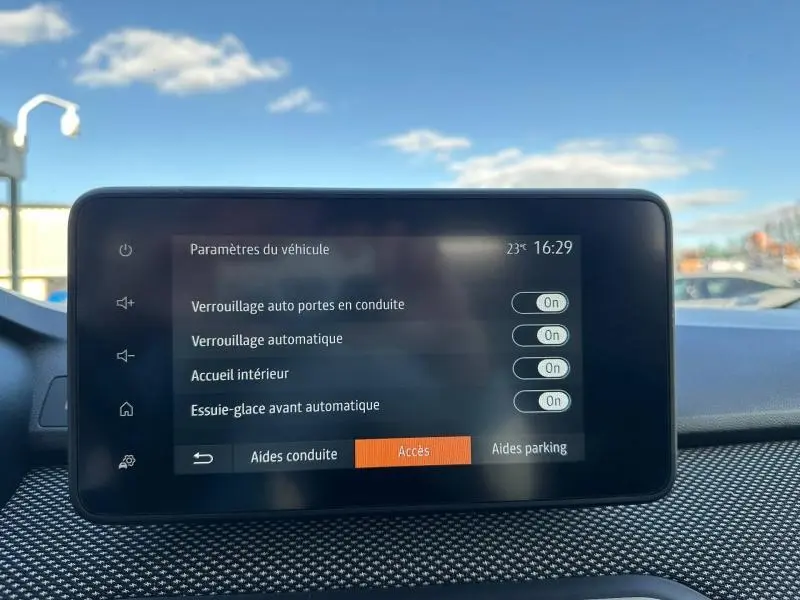 Écran tactile central du tableau de bord du Dacia Jogger 2025 affichant les paramètres de verrouillage et essuie-glace automatique.