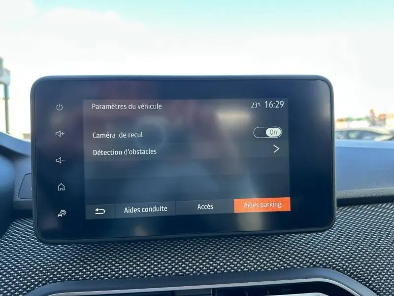 Écran tactile intérieur du Dacia Jogger 2025 affichant les paramètres d’aide au stationnement, vue frontale rapprochée.