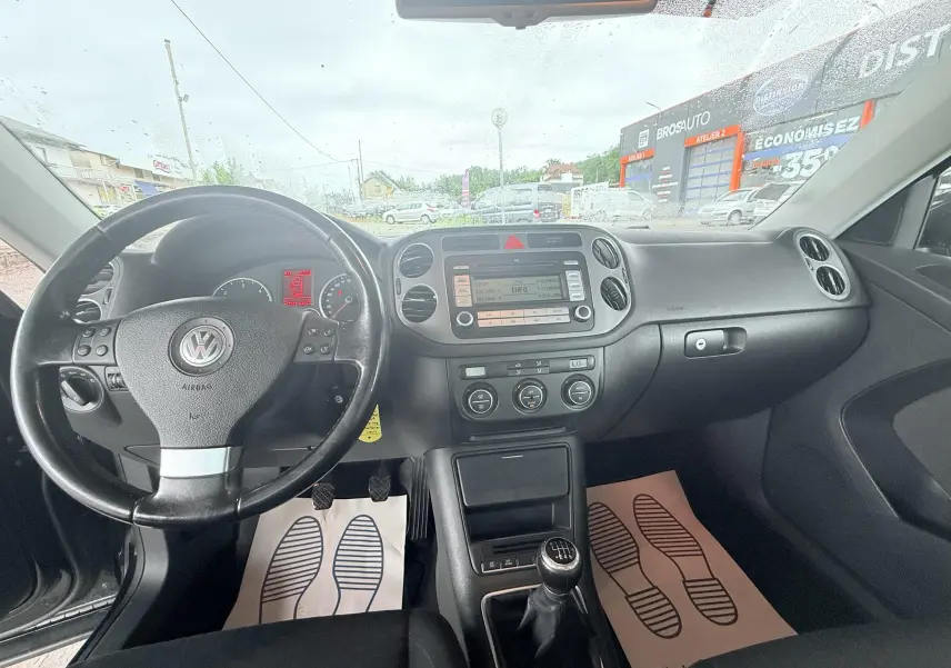 Vue intérieure avant du Volkswagen Tiguan 2007 avec tableau de bord noir et volant multifonctions.