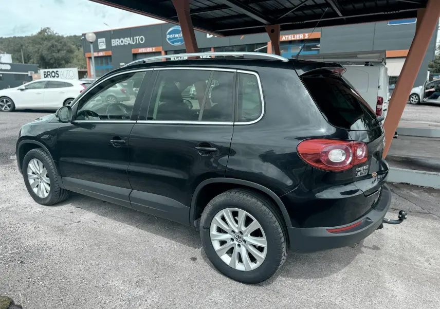 Volkswagen Tiguan noir vu de côté droit arrière, avec attelage et jantes alliage 17 pouces.