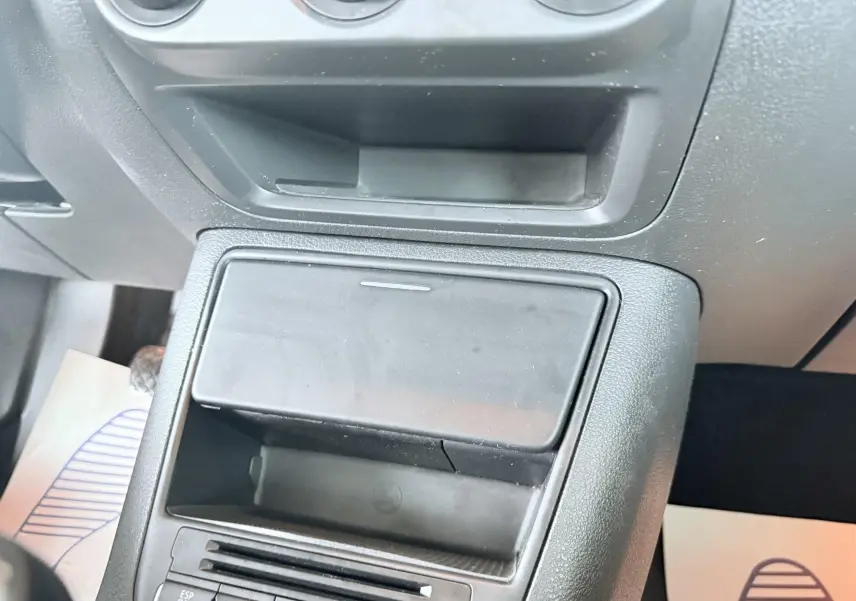 Vue rapprochée de la console centrale noire du Volkswagen Tiguan 2007, avec rangement et commandes visibles.