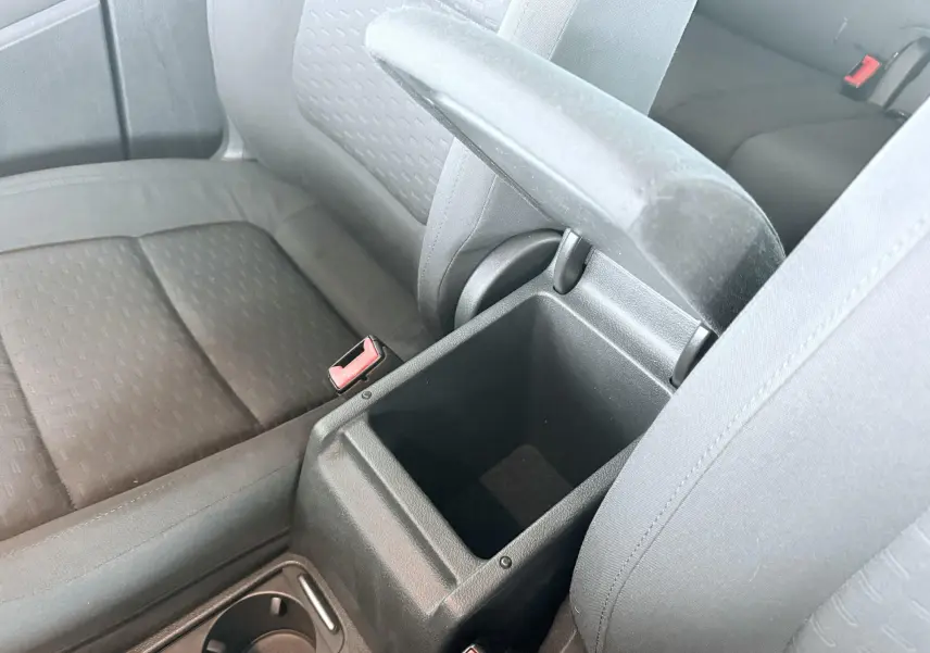 Vue intérieure rapprochée du coffre central ouvert entre les sièges avant noirs en tissu du Volkswagen Tiguan 2007.