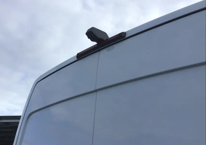 Vue rapprochée sur la partie arrière haute d’un Renault Master blanc, mettant en valeur la caméra de recul intégrée.