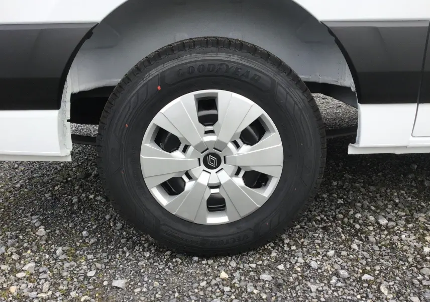 Gros plan sur la roue avant droite du Renault Master blanc avec jante argentée et pneu Goodyear tous temps.