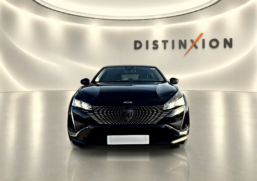 Vue frontale d'une Peugeot 408 noire 2025, avec calandre distinctive et phares LED allumés dans un showroom lumineux.