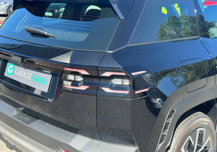 Vue 3/4 arrière droite du Jeep Compass 2026 couleur Vulcano avec feux arrière LED et jantes aluminium visibles.
