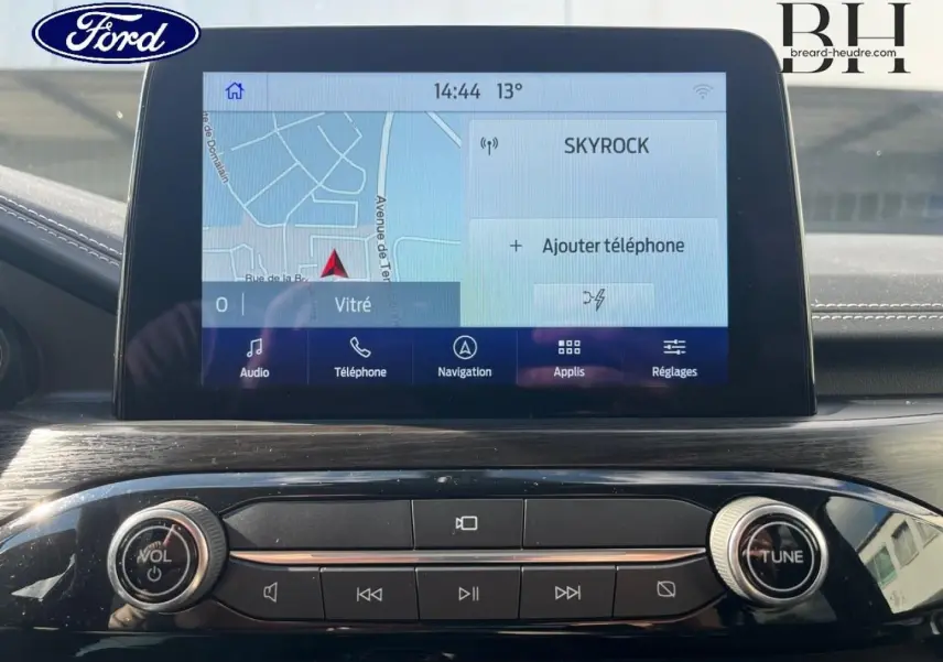 Vue rapprochée de l'écran tactile multifonction et de la console centrale noire brillante du Ford Kuga 2023.