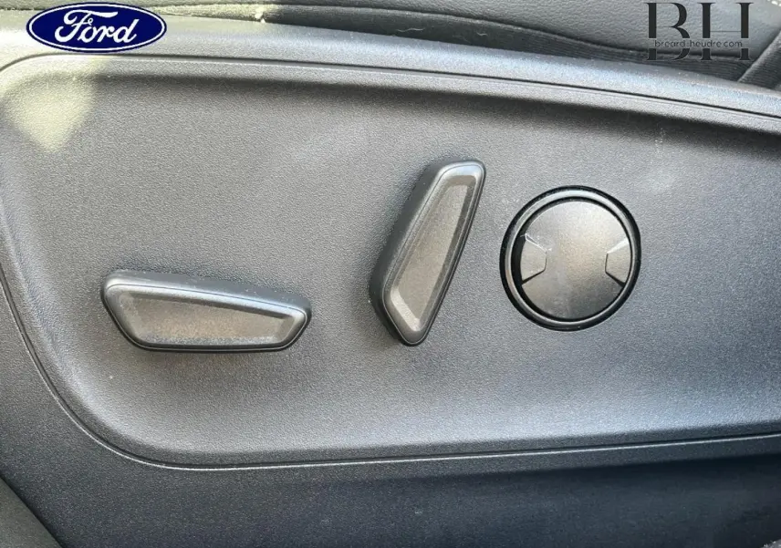 Détail des commandes de réglage électrique du siège côté gauche d’un Ford Kuga noir Agate Métallisée 2023.