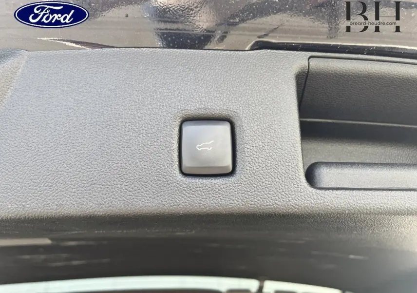Bouton d'ouverture électrique du coffre sur la garniture intérieure noire du Ford Kuga 2023 Noir Agate Métallisée.