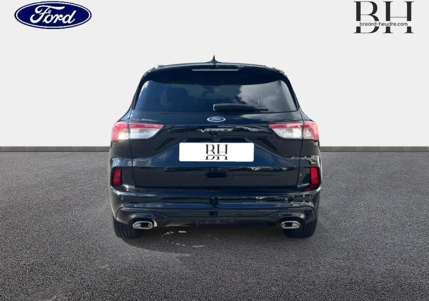 Vue arrière d'un Ford Kuga Vignale 2023 noir Agate métallisé avec double sortie d'échappement et lunette arrière surteintée.