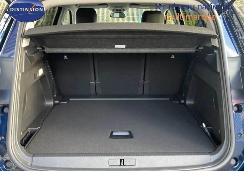 Coffre ouvert d'un Citroën C5 Aircross bleu Eclipse Metal, vue arrière montrant l'espace de chargement et la tablette cache-bagages.