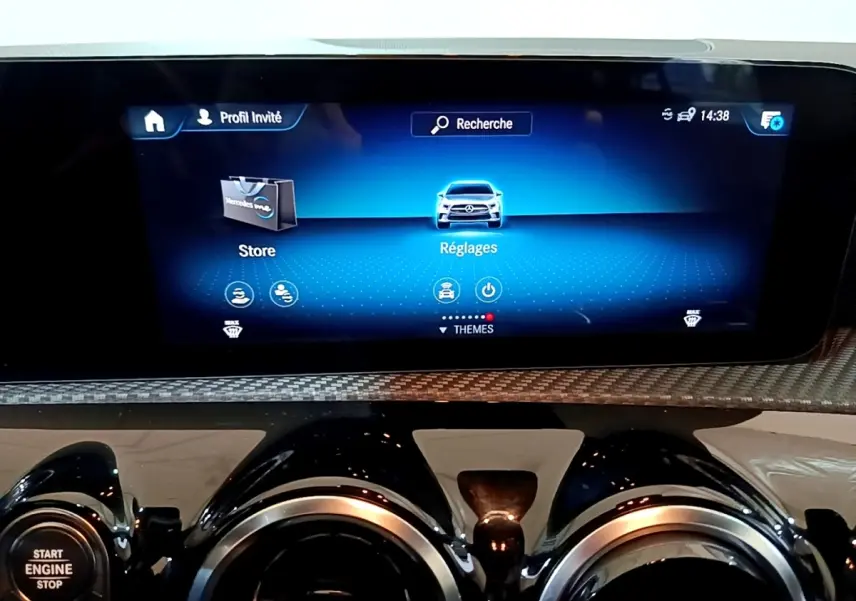 Vue rapprochée de l’écran tactile central et des aérateurs ronds noirs du tableau de bord gris foncé d’une Mercedes Classe A 180 d.