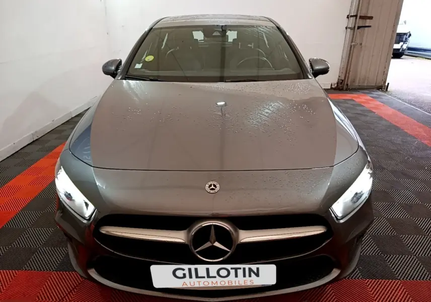 Vue avant d'une Mercedes Classe A 180 d Business Line gris foncé avec phares LED allumés dans un garage.