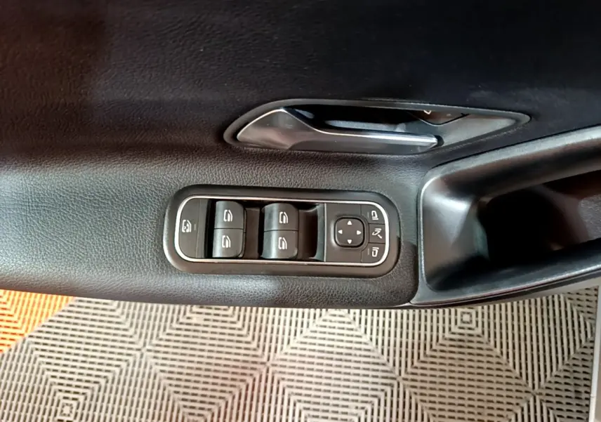Gros plan sur la porte intérieure côté conducteur de la Mercedes Classe A 180 d Business Line avec commandes de vitres et poignée noire.