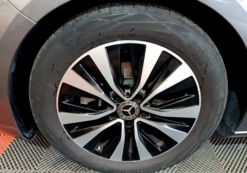 Gros plan sur la jante alliage bicolore noire et argentée du côté avant droit d'une Mercedes Classe A gris foncé.