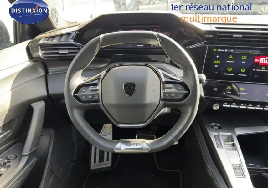 Vue intérieure centrée sur le volant cuir GT et le tableau de bord numérique de la Peugeot 408 gris selenium.