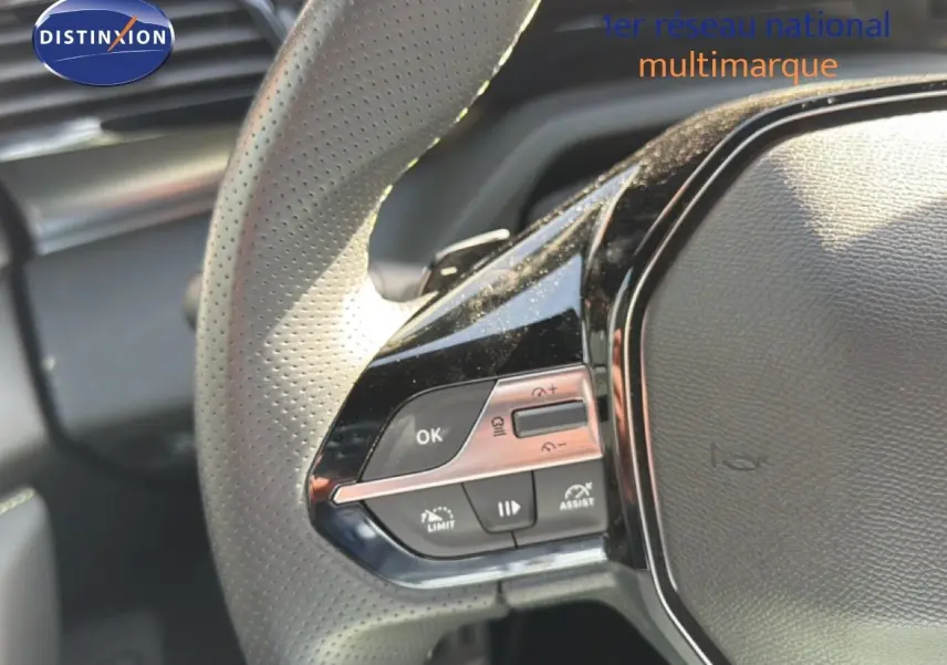 Gros plan sur les commandes multifonctions à gauche du volant perforé d'une Peugeot 408 gris Selenium 2025.