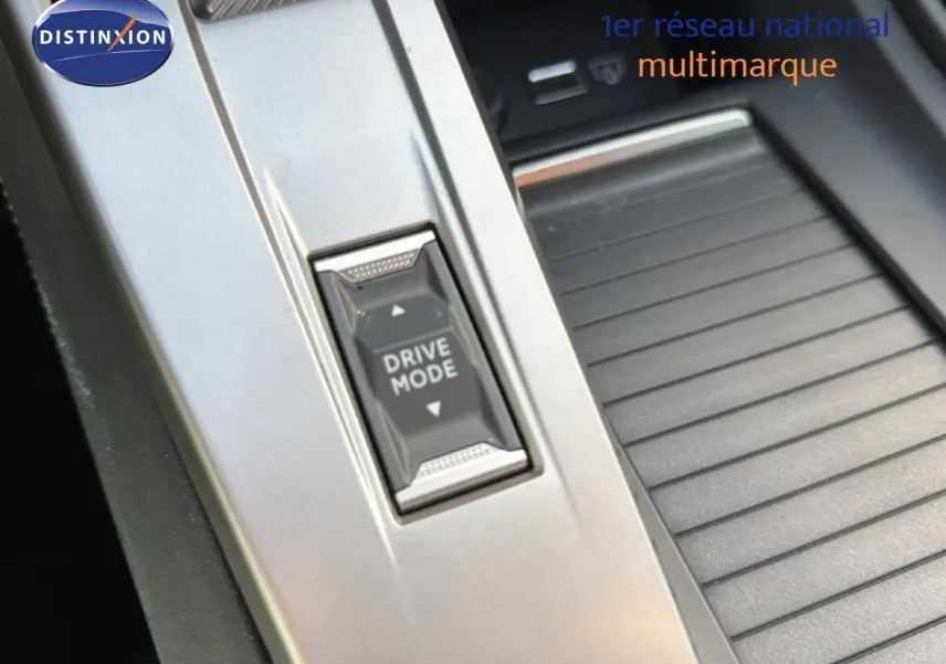 Gros plan sur le bouton Drive Mode dans la console centrale argentée d'une Peugeot 408 gris selenium metal 2025.