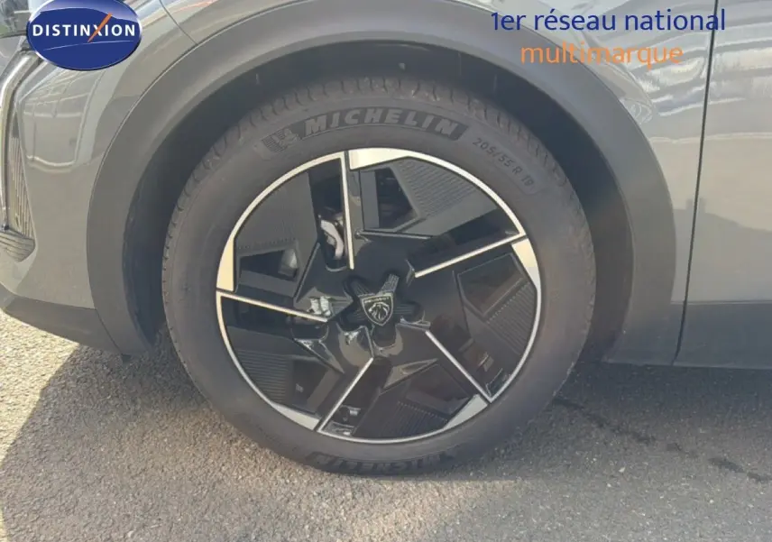 Gros plan sur la roue avant gauche d'une Peugeot 408 gris selenium metal, jante noire et argentée au design moderne.