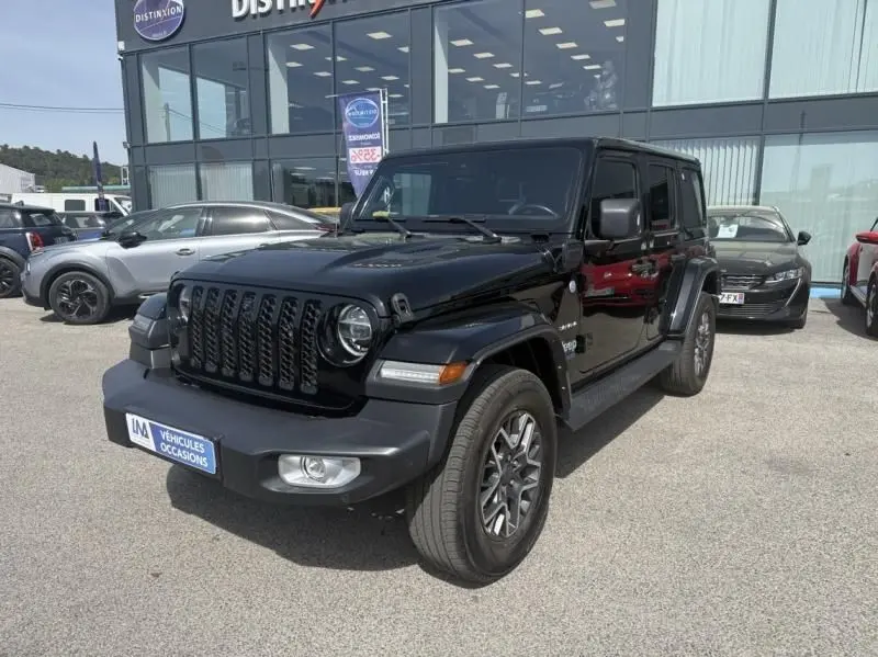 Jeep Wrangler Unlimited 2022 noir en 3/4 avant droit, avec calandre iconique et jantes alliage visibles.