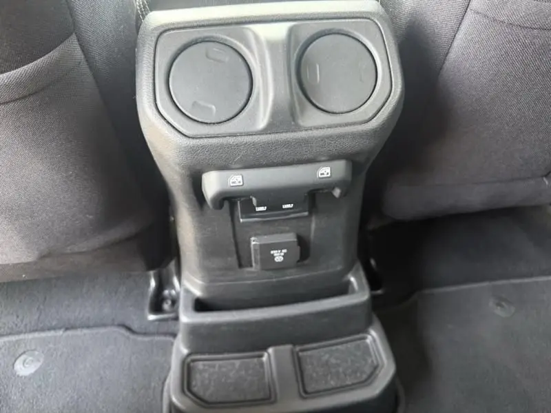 Détail intérieur montrant la console arrière noire avec prises USB et ports de recharge du Jeep Wrangler Unlimited 2022.