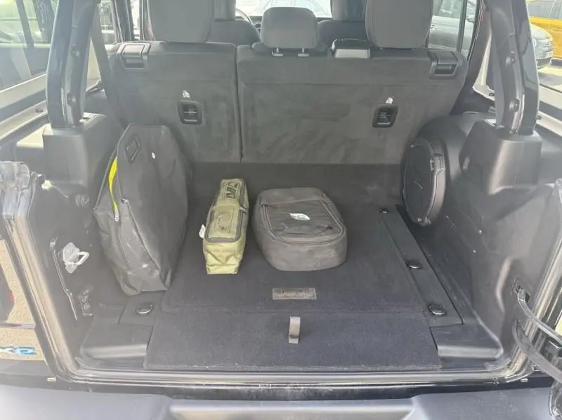 Coffre ouvert vu de l'arrière d'un Jeep Wrangler Unlimited noir 2022 avec sacs de rangement à l'intérieur.