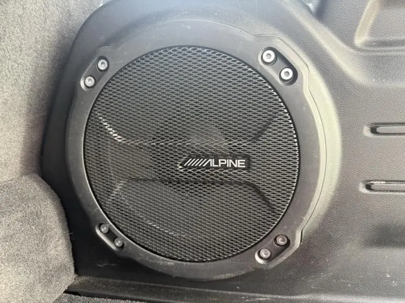 Gros plan sur le haut-parleur Alpine intégré dans le coffre du Jeep Wrangler Unlimited 2022 noir.