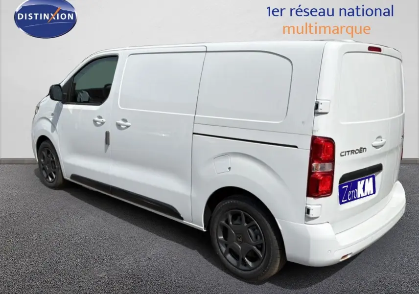 Vue 3/4 arrière droite d’un Citroën Jumpy blanc Kaolin avec jantes noires et porte latérale coulissante fermée.