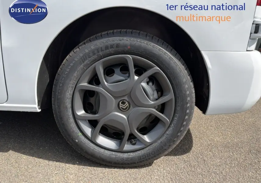 Gros plan sur la roue avant droite d’un Citroën Jumpy blanc Kaolin avec jante grise au design moderne.