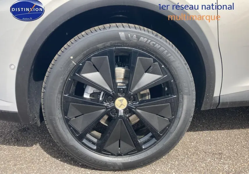 Gros plan sur la jante noire à design géométrique du DS7 Crystal Pearl côté gauche, avec pneu Michelin visible.
