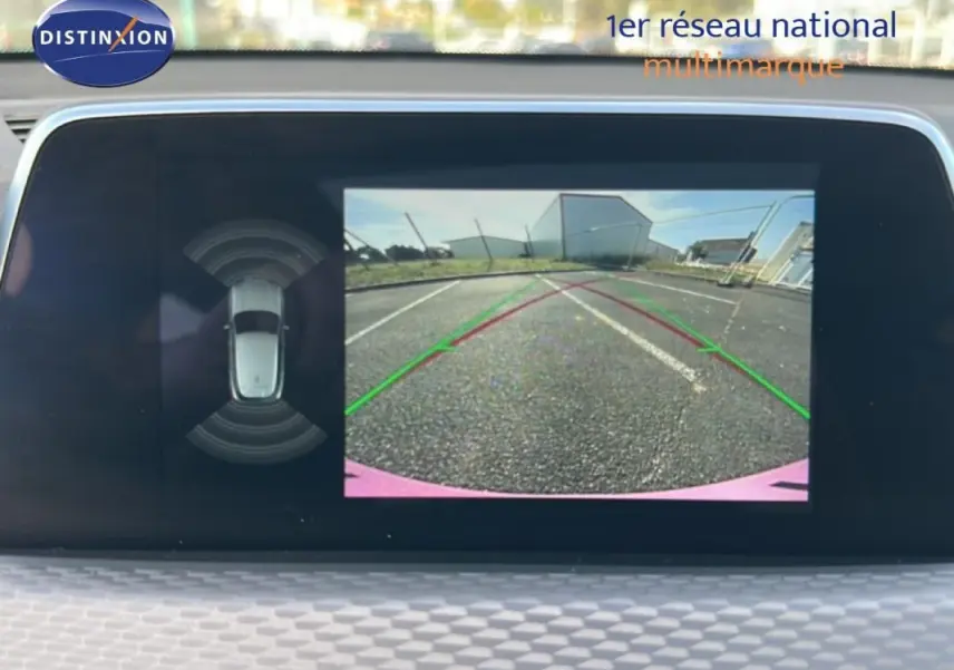 Écran de caméra de recul de BMW X2 blanc montrant l’arrière avec lignes de guidage et vue 360° du véhicule.