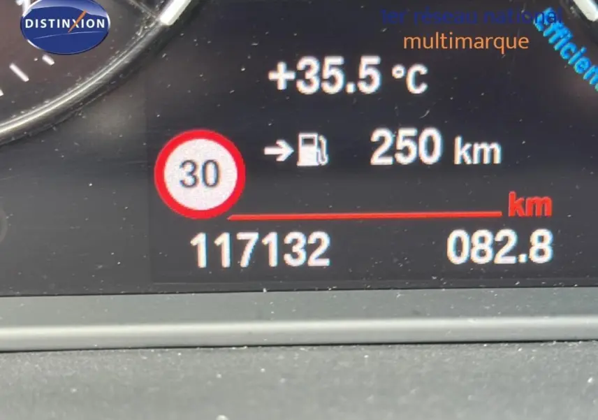 Affichage numérique du tableau de bord de la BMW X2 blanc montrant la température, autonomie et kilométrage.