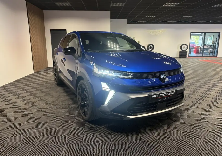 Renault Symbioz bleu Iron en 3/4 avant droit, avec calandre noire et feux LED allumés dans un showroom.