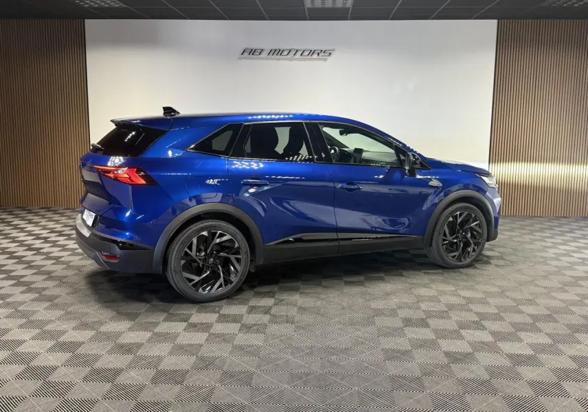 Vue latérale droite du Renault Symbioz 1.6 E-Tech Hybride bleu Iron avec jantes noires et détails noirs brillants.