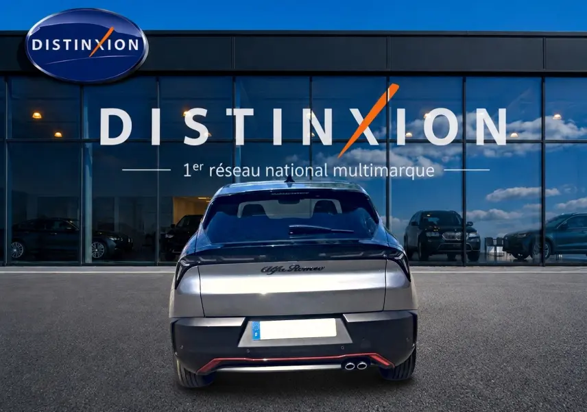 Vue arrière d'une Alfa Romeo Junior 1.2 hybride grise, avec double sortie d'échappement et hayon électrique visible.