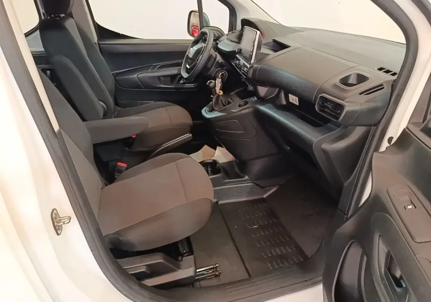 Vue intérieure côté conducteur du Peugeot Partner blanc 2020, montrant les sièges avant et le tableau de bord moderne.