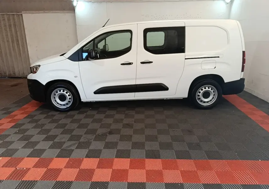 Vue de profil côté gauche d’un utilitaire Peugeot Partner blanc avec portes latérales et jantes acier simples.