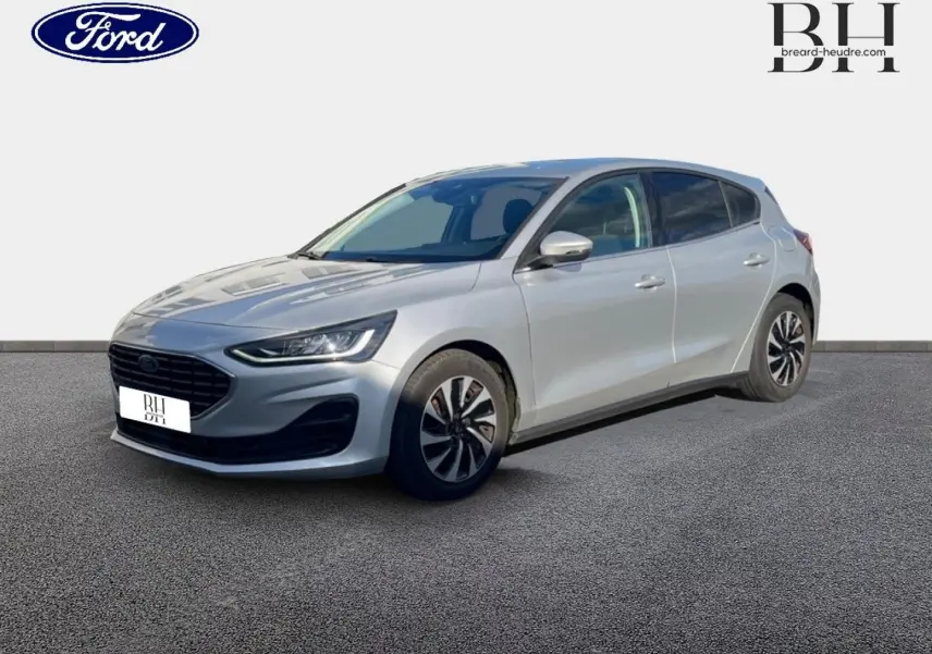 Ford Focus 2023 gris lunaire métallisé vue 3/4 avant droit avec calandre noire et jantes bicolores.