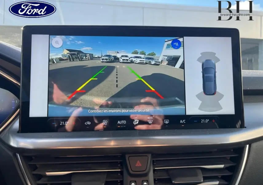 Écran tactile intérieur montrant la caméra de recul et l’aide au stationnement de la Ford Focus gris lunaire 2023.