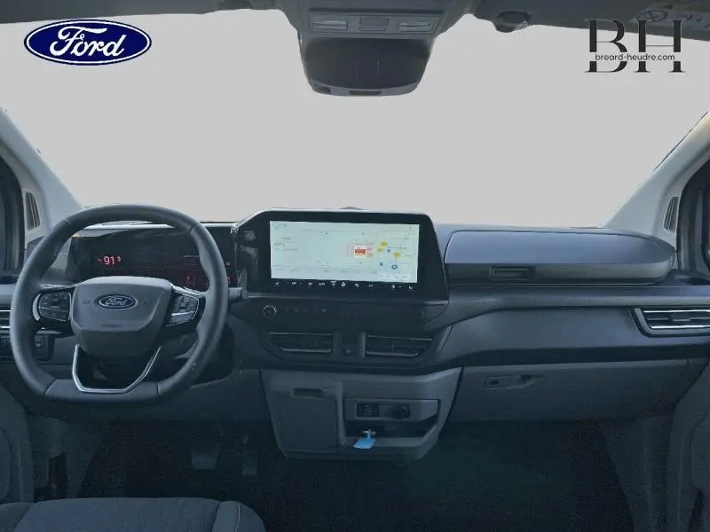 Vue intérieure du tableau de bord et volant du Ford Transit Custom Fourgon 2025 avec écran tactile et commandes intégrées.