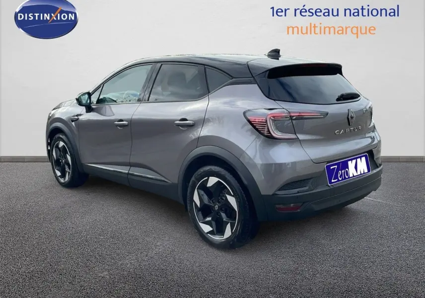 Renault Captur E-Tech hybride gris cassiopée avec toit noir, vue 3/4 arrière côté gauche, jantes bicolores distinctives.