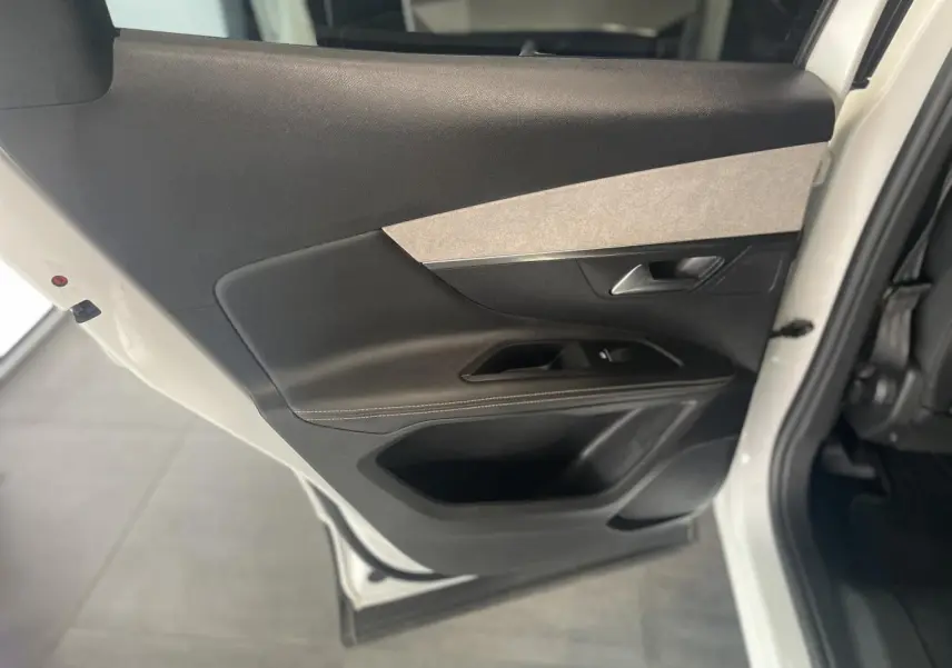 Vue rapprochée de la porte arrière droite blanche nacrée du Peugeot 3008 GT avec insert gris clair et garniture noire.